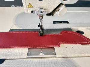 Close-up van JUKI LU-2810A-7 industriële stikmachine met digitaal bedieningspaneel.