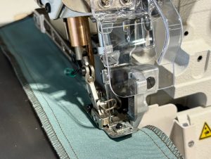 Close-up van de JUKI MO-6716DA overlocknaalden en semi-droogkop ontwerp