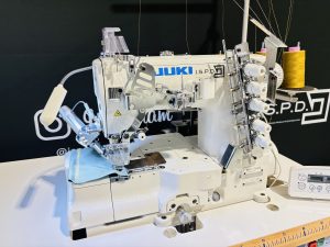 Automatische persvoetlichting en draadafsnijder in werking op de JUKI coverlock